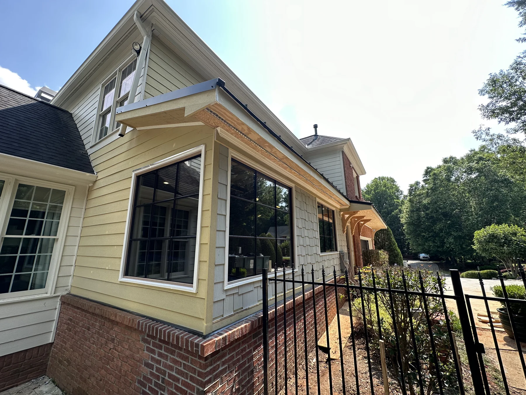 Black steel-framed window system installed across a residential patio wall